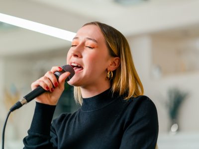 young girl sings in a vocal lesson with a microphone in her hands during a lesson at a music school