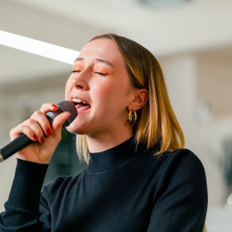 young girl sings in a vocal lesson with a microphone in her hands during a lesson at a music school